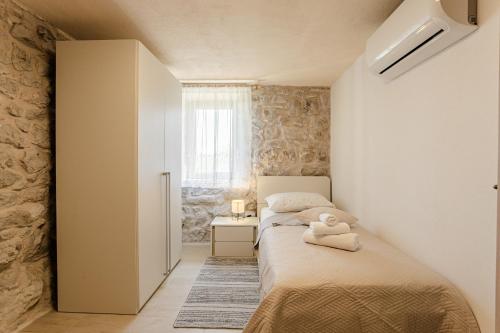 ein kleines Schlafzimmer mit 2 Betten und einem Fenster in der Unterkunft Patakun holiday home for 5, with heated pool in Lećevica