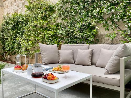 eine weiße Couch mit einem Tisch mit Essen drauf in der Unterkunft Fragile Hotel in Ciutadella