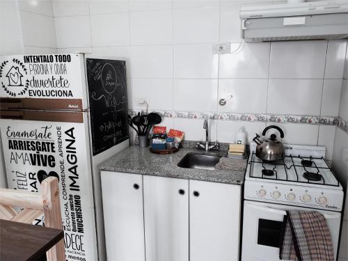 a small kitchen with a stove and a sink at FyD Apart in San Miguel de Tucumán