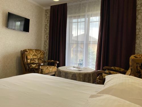 a hotel room with a bed and a table and a window at NESS готельно-ресторанний комплекс in Luts'k