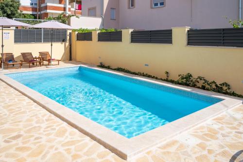 a swimming pool in front of a building at Apartments Dijana in Zadar