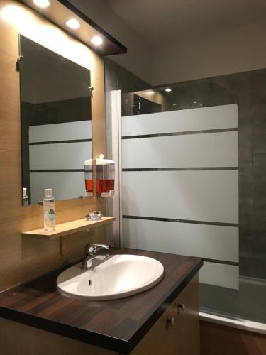 une salle de bain avec un lavabo et un miroir dans l'établissement Crocus Résidence Cybele, à Brides-les-Bains