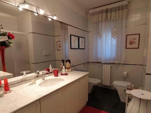 uma casa de banho com um lavatório, um WC e um espelho. em Fior di Loto em Ancona