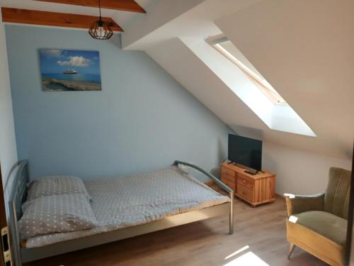 a bedroom with a bed and a chair at Guliwer in Niechorze
