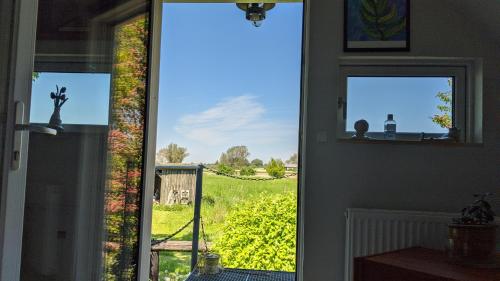 a door with a view of a field of vines at Under Valnødden in Stubbekøbing