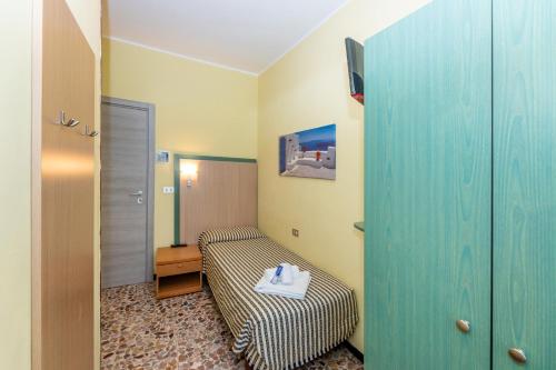 a small room with a bed and a mirror at Villa Adriana in Pietra Ligure