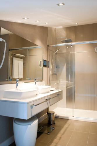 a bathroom with two sinks and a shower at Costa Esmeralda Suites in Suances