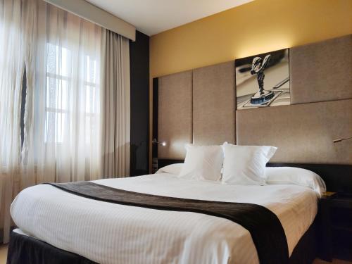 a hotel room with a large bed with white pillows at Costa Esmeralda Suites in Suances