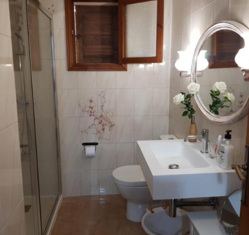 a bathroom with a sink and a toilet and a mirror at YourHouse Cas Sito in Cala Tuent