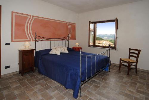 Un dormitorio con una cama azul y una ventana en Agriturismo Rio Sordo, en Barbaresco