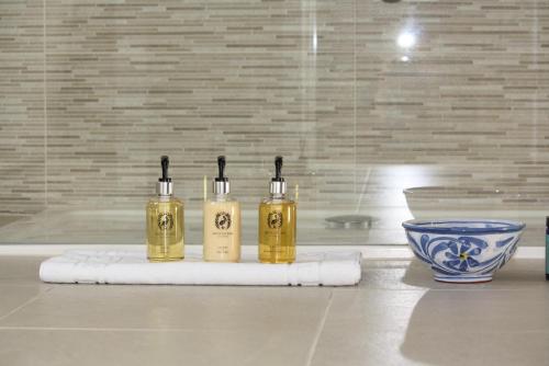 three bottles of oil sitting on a towel next to a bowl at Tawburn House Boutique B & B in Okehampton