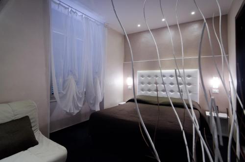 um quarto com uma cama e uma janela com cortinas em Londrino Sanremo em Sanremo