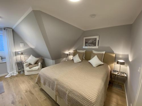 ein Schlafzimmer mit einem Bett in einem Zimmer im Dachgeschoss in der Unterkunft Haus Oscar in Westerland in Westerland