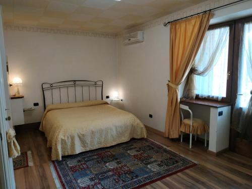 a bedroom with a bed and a window and a rug at B&B Ernestina in Miane