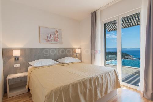 een slaapkamer met een bed en uitzicht op de oceaan bij Apartment Stanley with Private Pool in Makarska