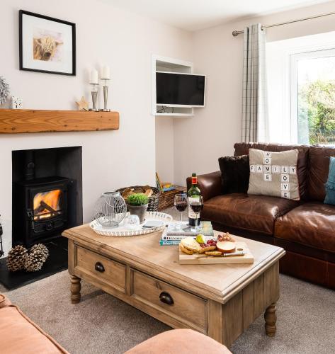 a living room with a coffee table with food on it at Smithy Cottage in Kirkmichael