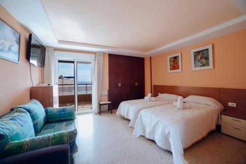 une chambre d'hôtel avec deux lits et un canapé dans l'établissement Coblanca 8-5º, à Benidorm
