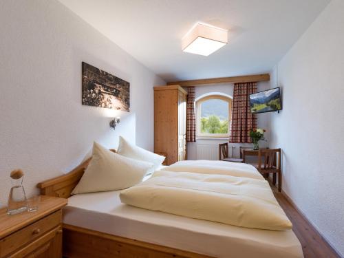 a bedroom with a white bed with a window at Appart Klocker in Kaltenbach