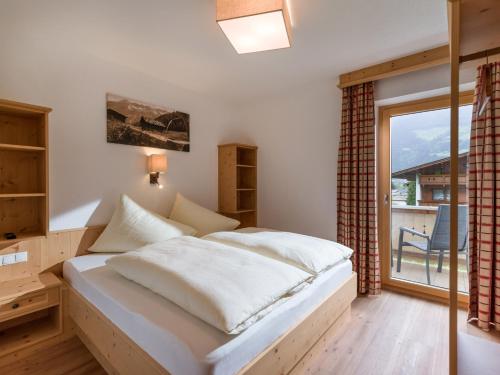 um quarto com uma cama e uma grande janela em Appart Klocker em Kaltenbach