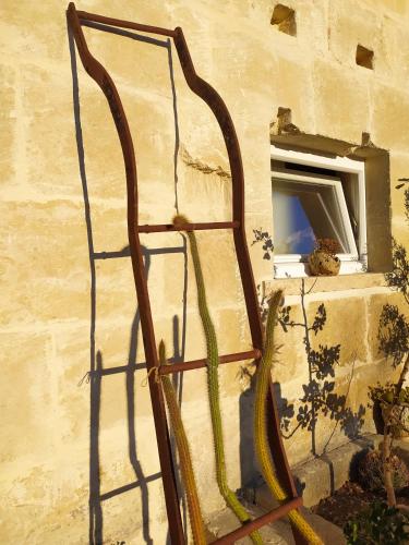 a metal sculpture of a ladder leaning against a wall at Giardino Frannicola in Maglie