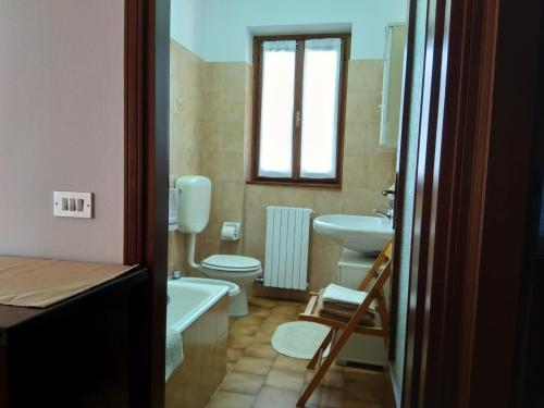 a bathroom with a toilet and a sink and a tub at Casa Bella Vista in Baveno