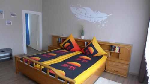 1 dormitorio con cama de madera y almohadas coloridas en Alte Tischlerei, en Essel
