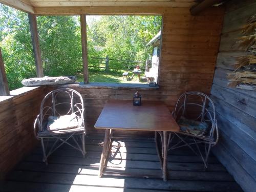 a table and two chairs on the porch of a cabin at Toomarahva Farmstay in Altja