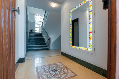 a hallway with a mirror on the wall and a staircase at Villa Adriana in Pietra Ligure