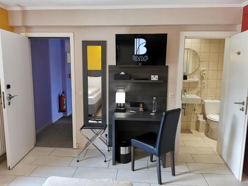 La salle de bains est pourvue d'un bureau, d'un lavabo et de toilettes. dans l'établissement BIVIUS Hotel Restaurant Luxembourg, à Luxembourg
