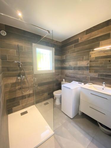 une salle de bain avec une douche, des toilettes et un lavabo dans l'établissement Villa deux chambres avec piscine chauffee proche des plages, à Sainte-Lucie de Porto-Vecchio