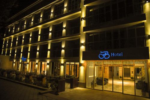 a hotel at night with a sign in front of it at B Hotel Bishkek in Bishkek