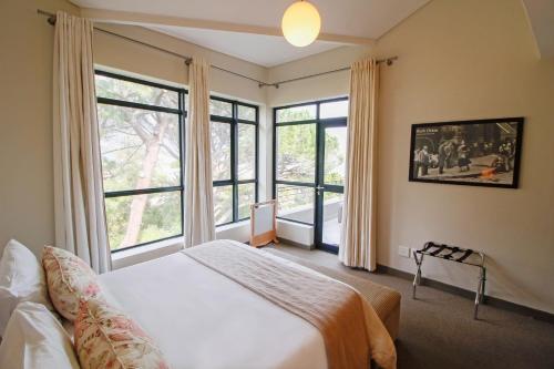 a bedroom with a bed and a large window at The Glen Apartments in Cape Town