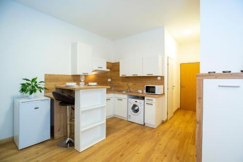 a kitchen with white cabinets and a sink and a stove at Agro Complex Apartments in Nitra