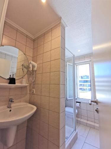 a bathroom with a sink and a mirror at BIVIUS Hotel Restaurant Luxembourg in Luxembourg