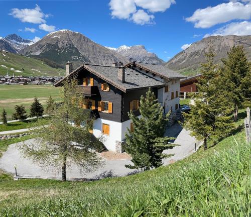 une vue aérienne sur une maison avec des montagnes en arrière-plan dans l'établissement Bait Panorama, à Livigno