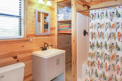 a bathroom with a sink and a shower curtain at Arbor House of Dripping Springs - Finch House in Dripping Springs