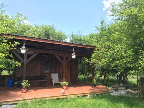 a cabin in the woods with a wooden deck at Romantická chatka so saunou v prírode in Turany