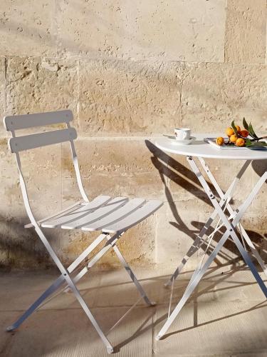 a chair and a table with a plate of fruit at Giardino Frannicola in Maglie