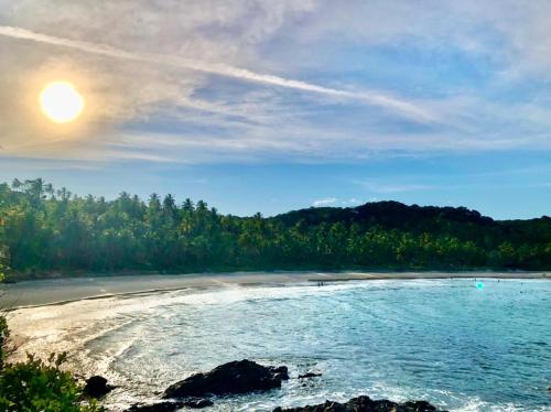 a view of a beach with the sun in the sky at Maré Mansa Pousada e Hostel in Itacaré