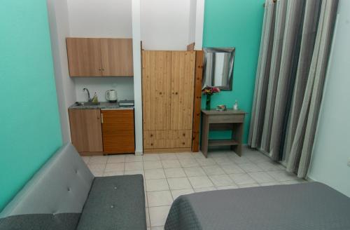 een kleine kamer met een bed en een keuken bij Ampelaki Studios in Boukari