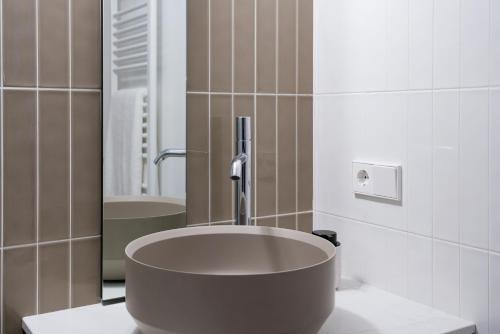 a bathroom with a large sink and a mirror at SEIS ALDABAS Apartamentos in Santiago de Compostela