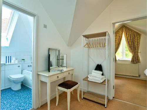 een badkamer met een wastafel, een toilet en een spiegel bij School Path Ironbridge Home with Rear Terrace in Ironbridge