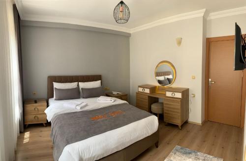a bedroom with a bed and a desk and a mirror at İmera Suite Otel in Uzungol