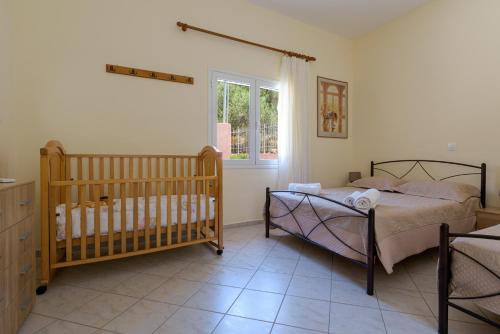 a bedroom with two twin beds and a crib at Palm Beach House in Sfinárion