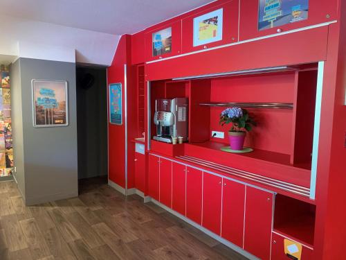 a red wall in a store with a coffee machine at hotelF1 Villepinte Parc des Expositions in Villepinte