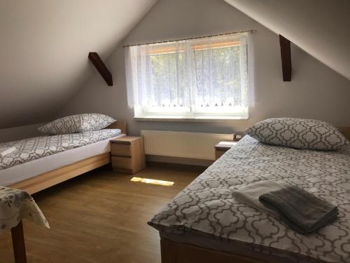 a bedroom with two beds and a window at Domek Damianki - cały dom in Zawoja