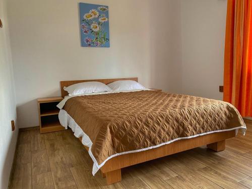 a bedroom with a bed with a brown bedspread at Lovin's Rooms in Tuzla