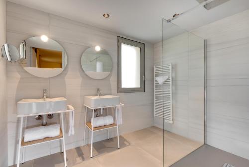 a bathroom with two sinks and two mirrors at Château Fage La Maison des Vignes - Saint-Émilion in Arveyres