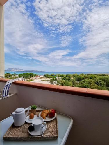 a table with two plates of food on a balcony at Hotel Onda Marina in San Teodoro