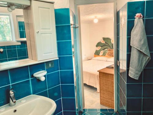 a bathroom with a sink and a bedroom at Pinelopi Room in Olbia